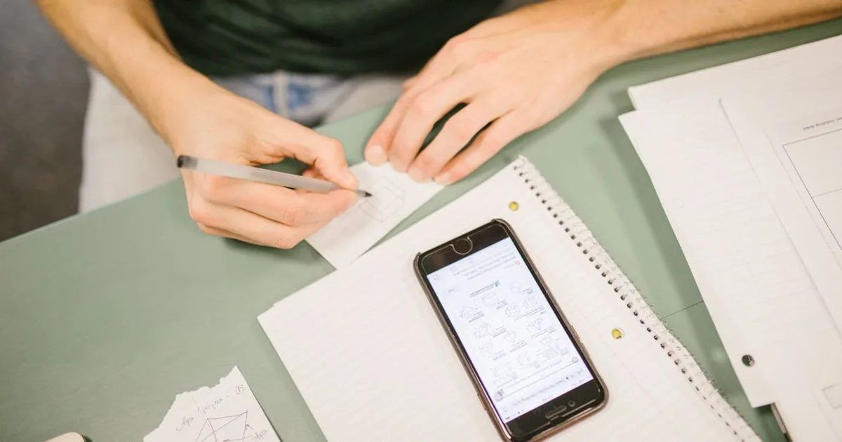 Person studying flashcards on a phone and laptop for exam prep