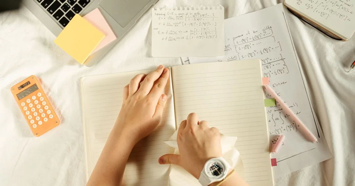 Person studying real estate exam notes and flashcards at a desk