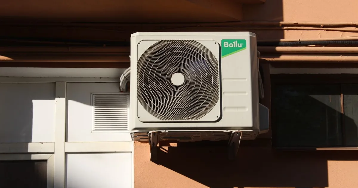 Residential outdoor split-system AC condenser next to a house (Type II equipment)