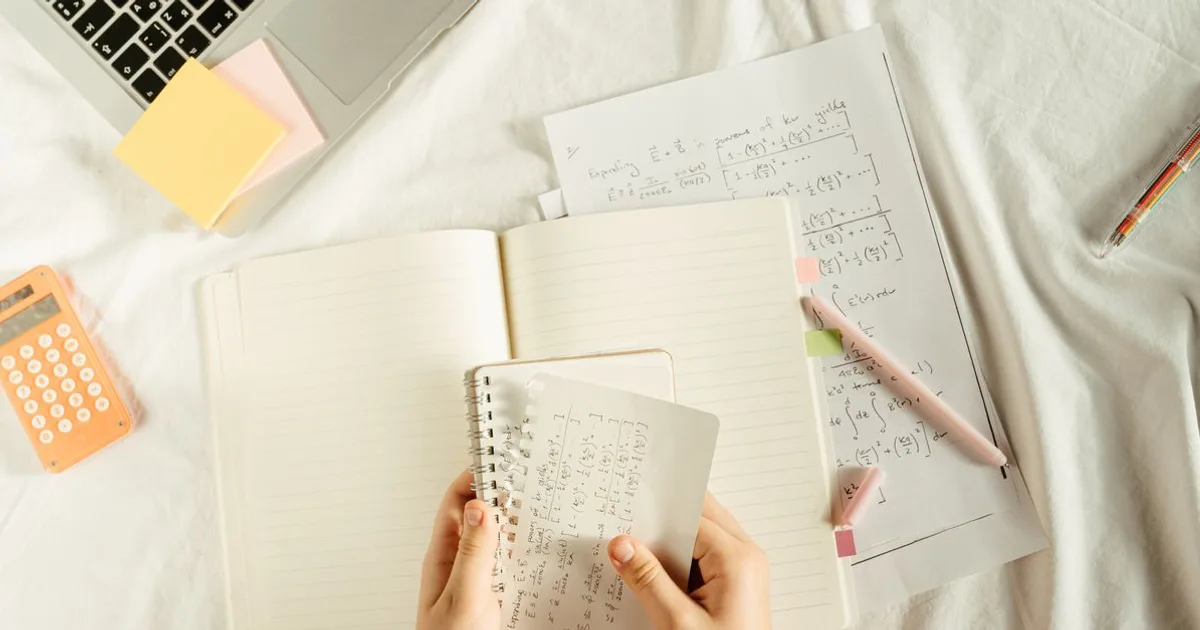 Notebook with handwritten finance formulas and calculator for exam prep