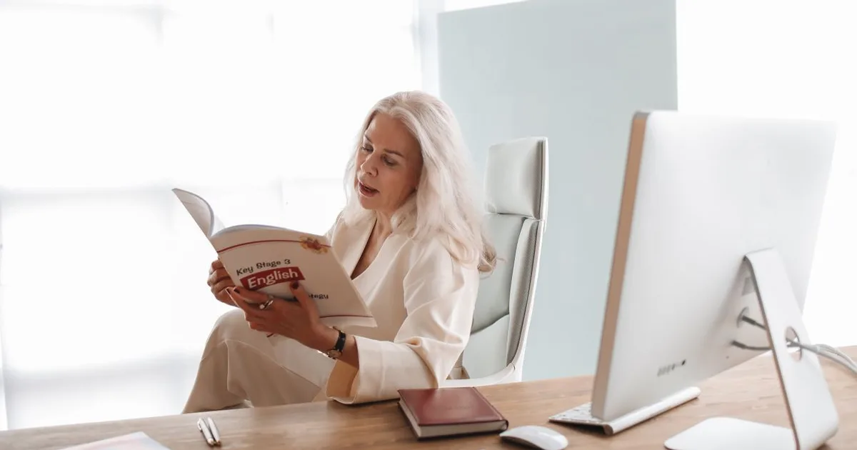 Adult studying language materials with books and notes at a desk