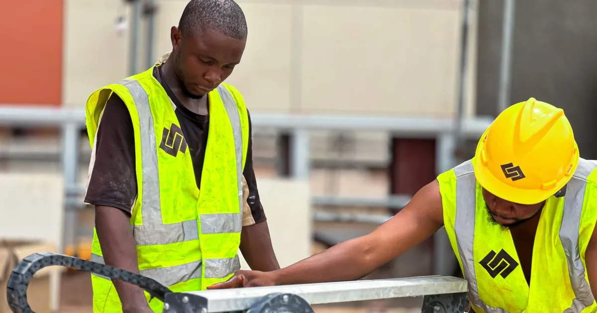 Construction workers in hard hats and high-visibility vests on an active building site