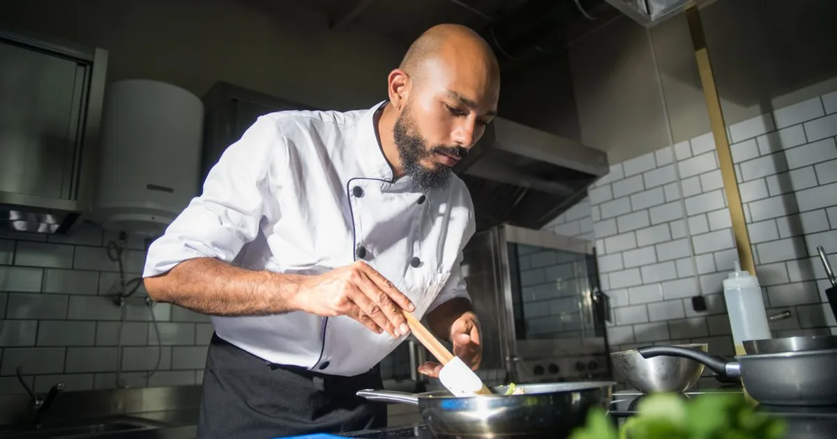 Chef preparing food in a modern commercial restaurant kitchen