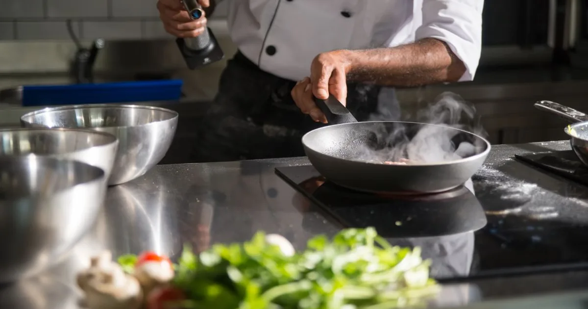 Restaurant kitchen manager checking food temperatures with a digital probe thermometer